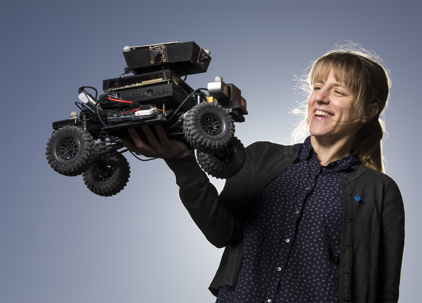 Student holding small car prototype